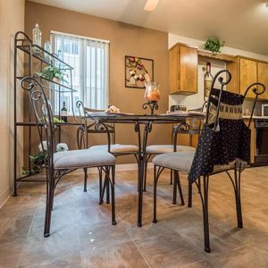 Model unit dining room and kitchen featuring custom cabinets, and appliances